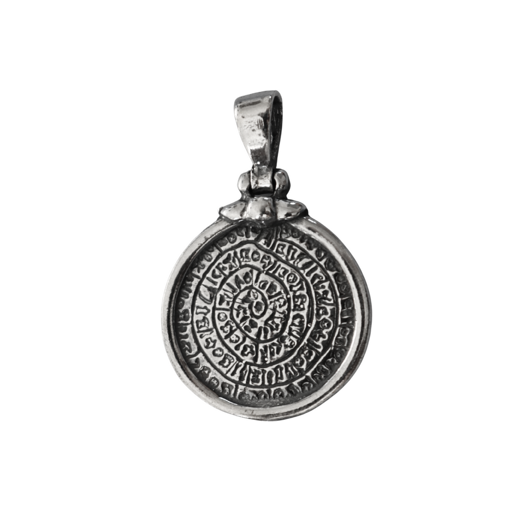 Silver pendant with intricate design on a white background